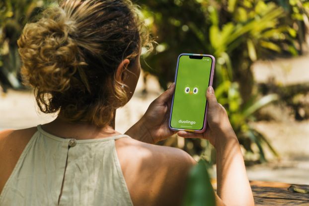 A woman using the Duolingo app on her smartphone