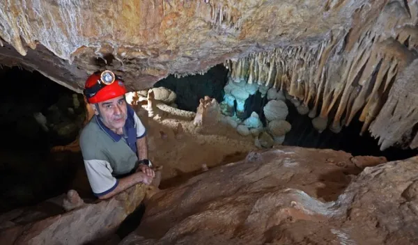 man with red hard hat in a cave