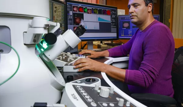 engineer looking into microscope