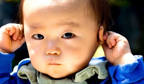 asian child pulling on its ears