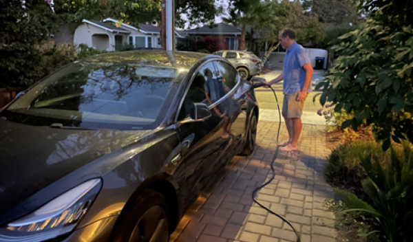 man plugging in electric car