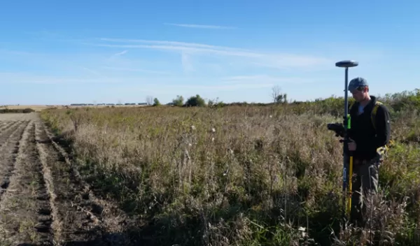 person surveying in a field