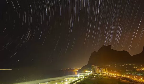 Star trials and light pollution over Rio beach at night