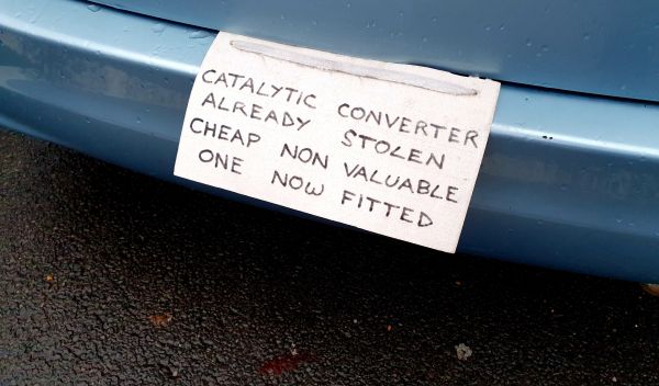 a written note on a car that says catalytic converter already stolen cheap non valuable one now fitted