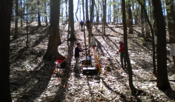 Researchers in the woods investigating rates of weathering in Pennsylvania.