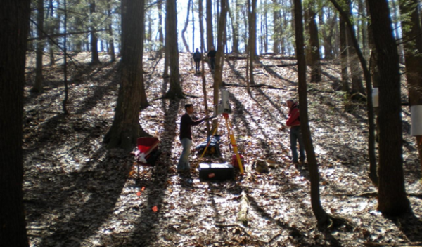Researchers in the woods investigating rates of weathering in Pennsylvania.