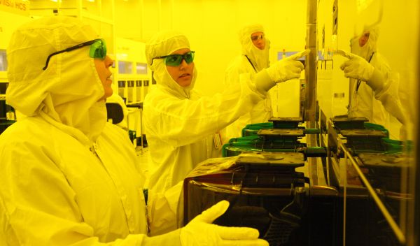 Technicians in clean room learn how to operate the equipment used to make semiconductors