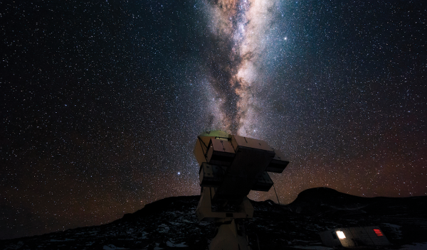 A telescope at night against the backdrop of the Milky Way.