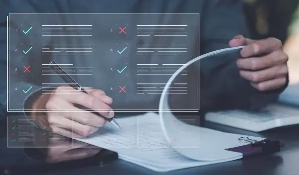 Person reviewing documents with a pen with checklist graphic overlayed