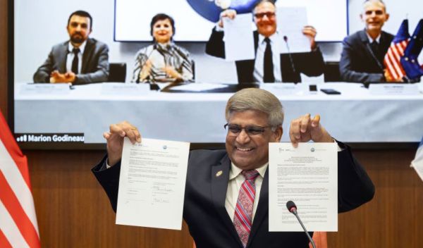 Director Panchanathan holding up documents.