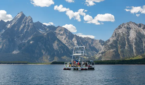 a boat in a body of water with a mountain background