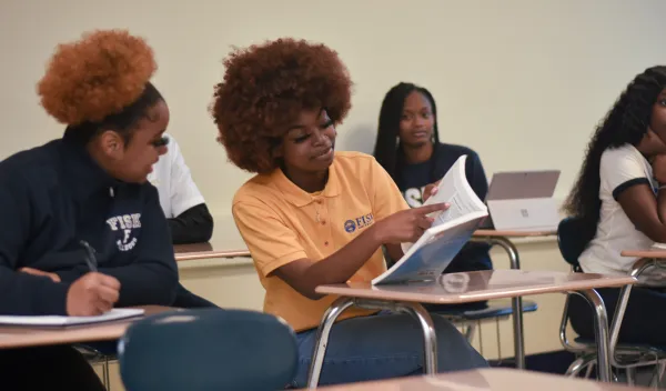 College students sitting at desks in a classroom.