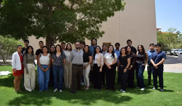 A diverse group of researchers, many of them students, gather for a group photo.