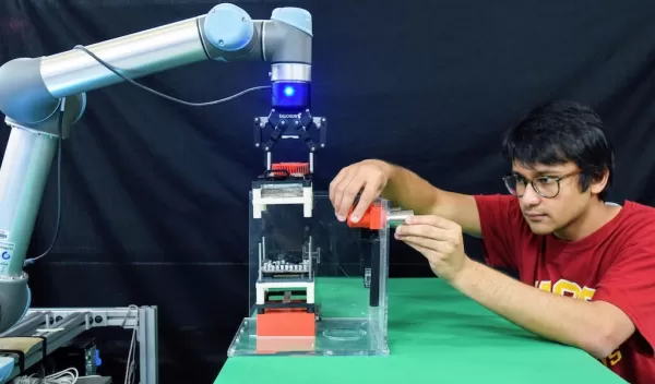 A HUMAN AND A ROBOT COLLABORATING TO PERFORM A CHALLENGING ASSEMBLY OPERATION. THIS IMAGE FEATURES PRAHAR BHATT, A GRADUATE STUDENT AT USC VITERBI SCHOOL OF ENGINEERING, AND A MOBILE MANIPULATOR DEVELOPED BY THE CENTER FOR ADVANCED  MANUFACTURING AT USC
