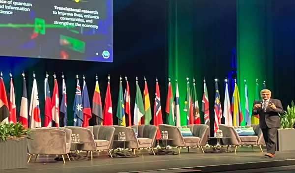 man standing on large stage giving a presentation