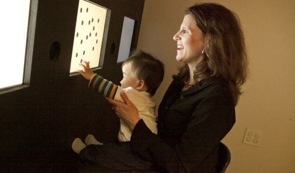 woman holding a baby touching a screen