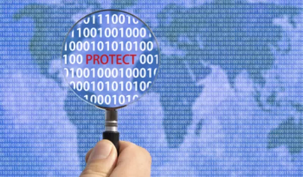 hand holding a magnifying glass over the world map with the word protect