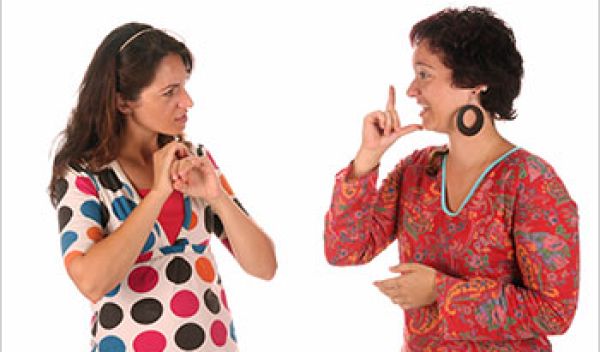 Two women communicate using sign language.
