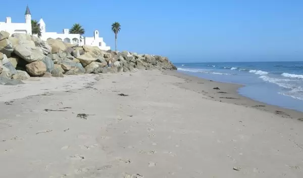 Large rock revetment in the intertidal zone of a sandy beach in Santa Barbara County, California.