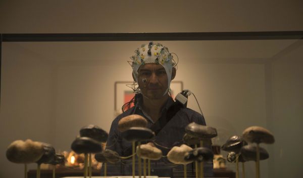 person with EEG cap looking at art