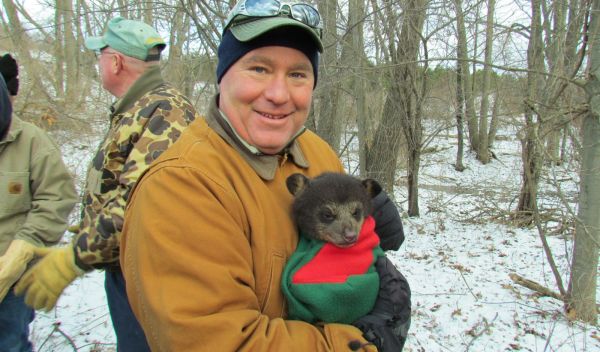 James Hewlett holds a black bear cub