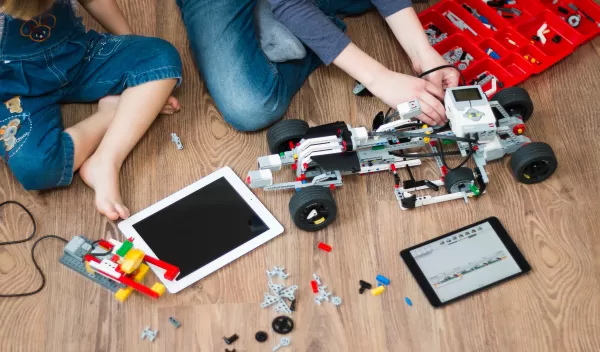 Two children work on a toy car.