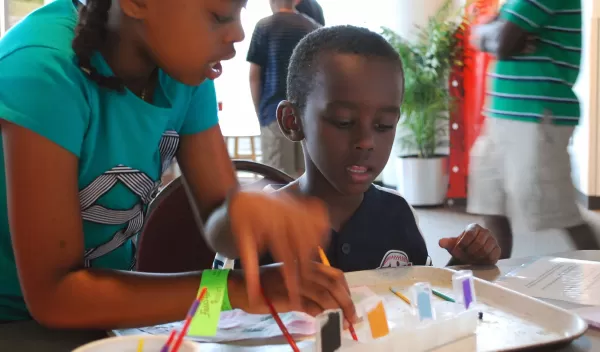 Young museum visitors use a paint set of acids and bases to learn about pH.