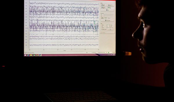 man looking at EEG data on the screen