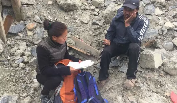 A woman research assistant interviews a quake survivor in Mustang District.