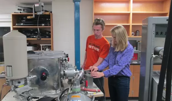 Students adjust the target wheel and detectors near a beam outlet