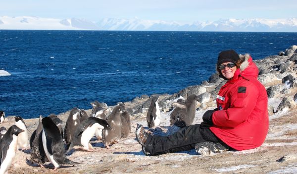 Jean Pennycook with group of Adélie penguins on the beach