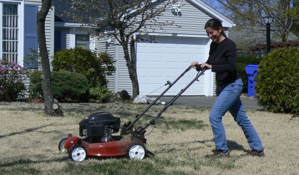 Woman mowing a lawn.