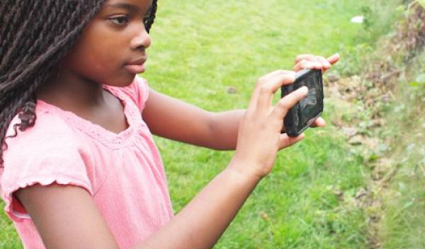 girl taking a photo of a plant with a smart phone