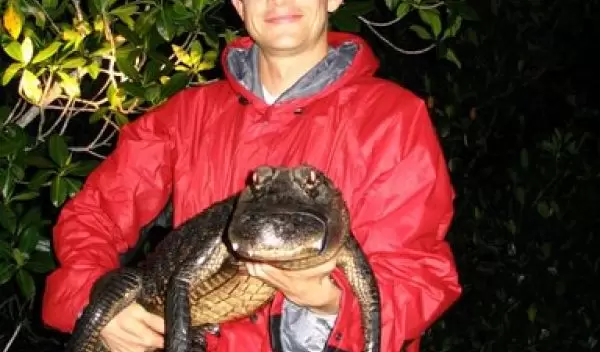 Photo of Adam Rosenblatt holding an alligator.