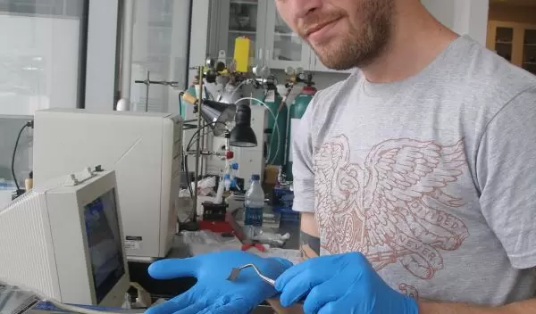 John Chmiola holds an electrochemical capacitor's electrode.