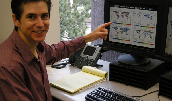 Photo of Peter Lawrence pointing to landcover changes on a computer screen.