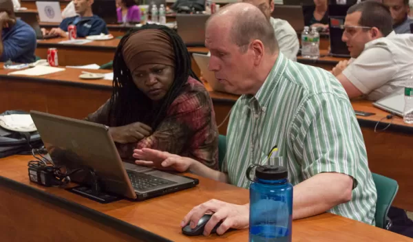 student and teacher working at a  computer