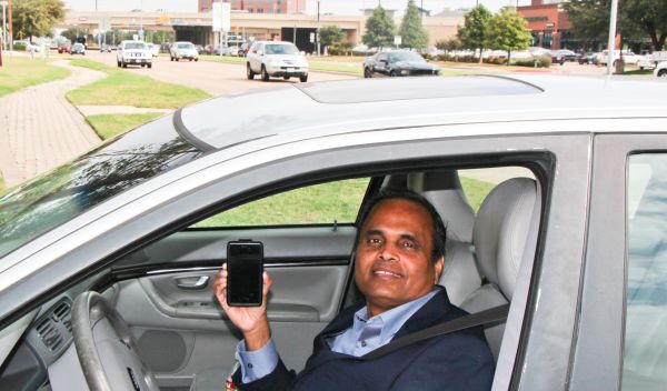 Photo of researcher Ram Dantu holding smart phone in his car.