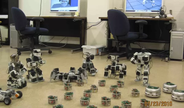 Photo of two computers and a terrestrial robot swarm