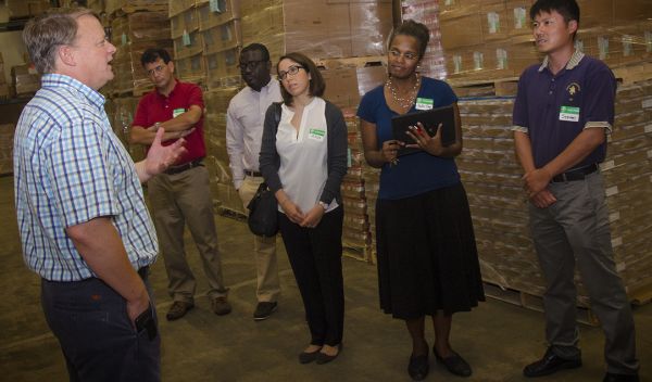 People stand in a food bank storage area.