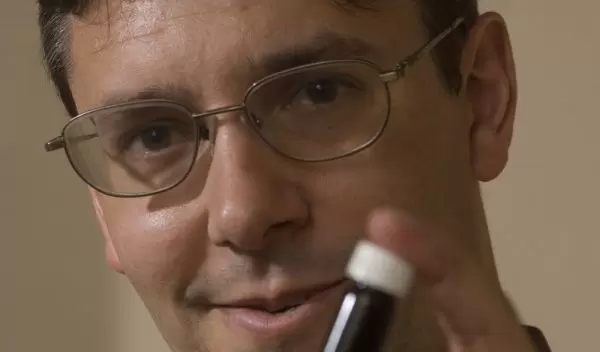 George Huber poses with a vial of green gasoline compounds.