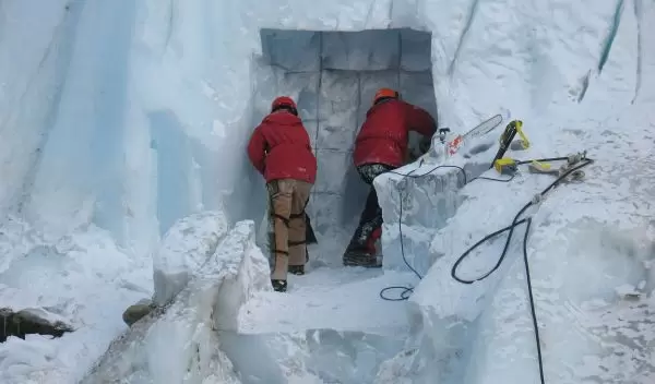 Photo of two people excavating a sampling tunnel into Taylor Glacier.