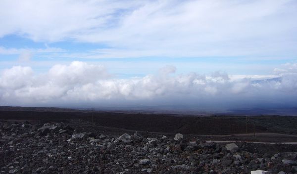 Photo of the twisting road, Mauna Loa's lava fields and clouds.