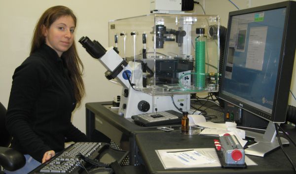 Photo of Susannah Gordon-Messer working on the fluorescence microscope used for her research.