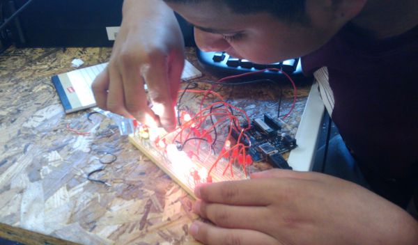 Photo of a student experimenting with using an Arduino microcontroller to power LEDs.