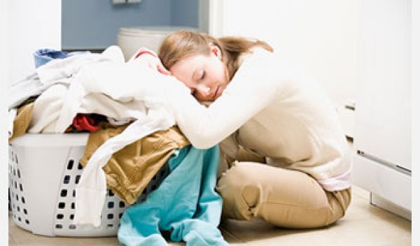 Photo of woman resting her head on basket of laundry.