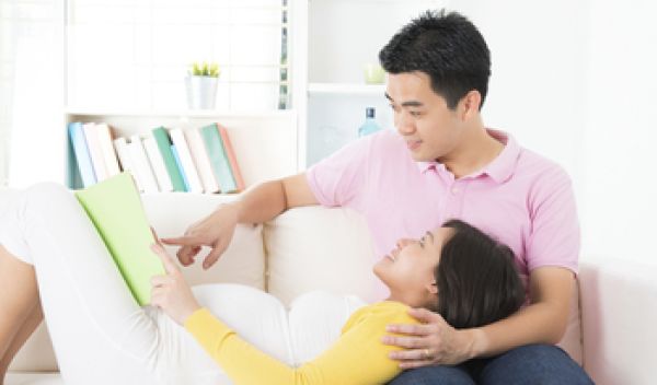 Mother and father reading to unborn baby.