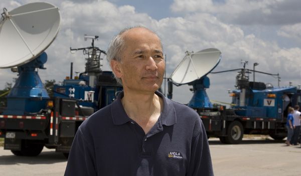 Photo of Roger Wakimoto with 2 satellite dish trucks in the background