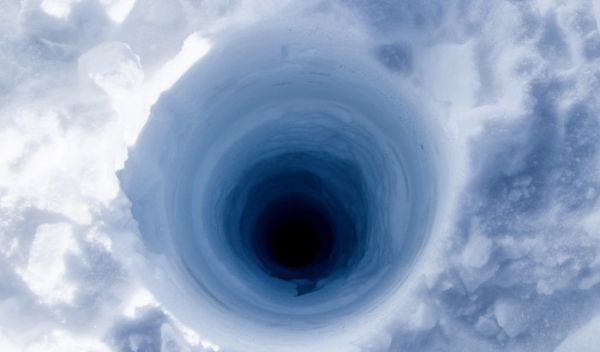 View looking down an ice coring borehole atop the Greenland ice sheet