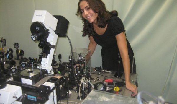 Photo of Markita Landry standing with a Total Internal Reflection Fluorescence Microscope.